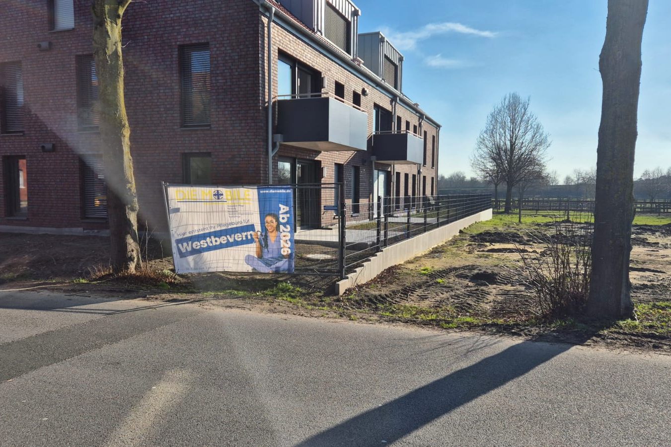 Tagespflege Telgte Gebäude in Telgte mit einem großen Schild und buntem Herbstbaum im Vordergrund.